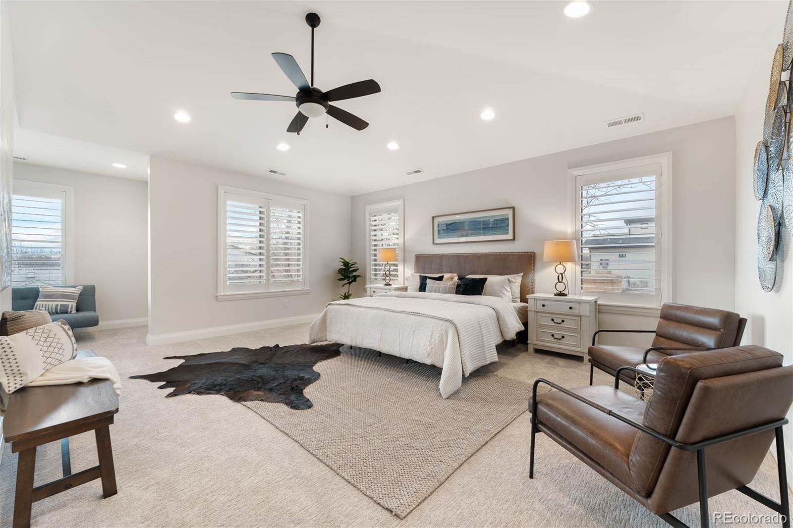 1645 South Cook Street Denver, CO 80210 - Photo 27 of 48 a spacious bedroom with a bed a couch and windows