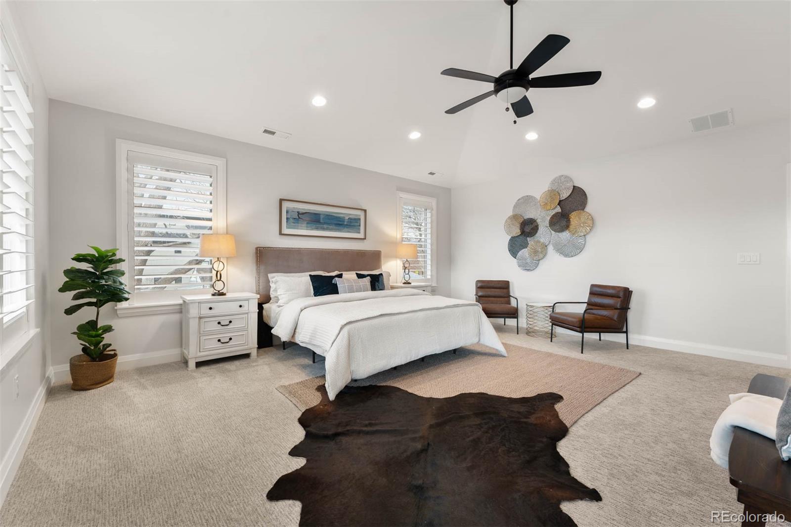1645 South Cook Street Denver, CO 80210 - Photo 28 of 48 a bedroom with a large bed and a chandelier
