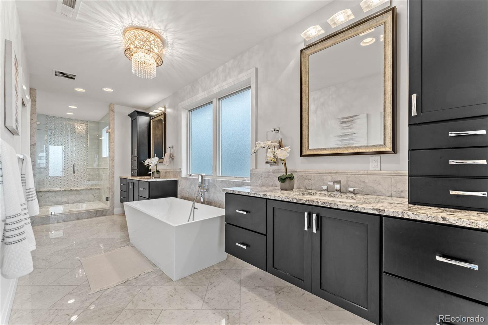 1645 South Cook Street Denver, CO 80210 - Photo 31 of 48 a spacious bathroom with a bathtub double sink and mirror
