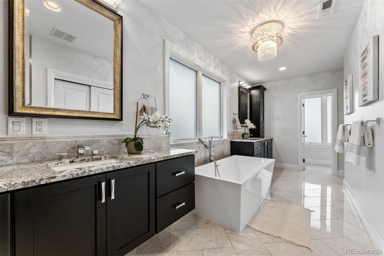 1645 South Cook Street Denver, CO 80210 - Photo 32 of 48 a spacious bathroom with a granite countertop sink a toilet a mirror and shower
