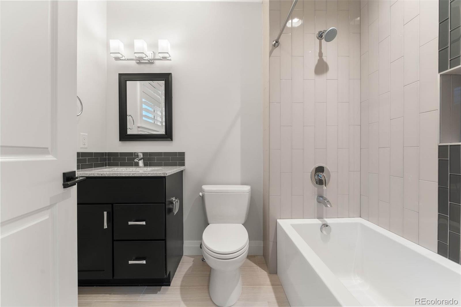 1645 South Cook Street Denver, CO 80210 - Photo 36 of 48 a bathroom with a toilet a sink and bathtub