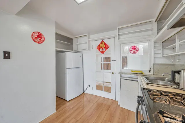 a kitchen with a refrigerator and a stove top oven