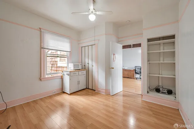 a view of empty room with wooden floor and window