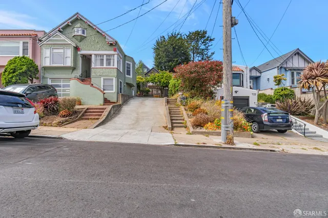 a view of a house with a yard and potted plants