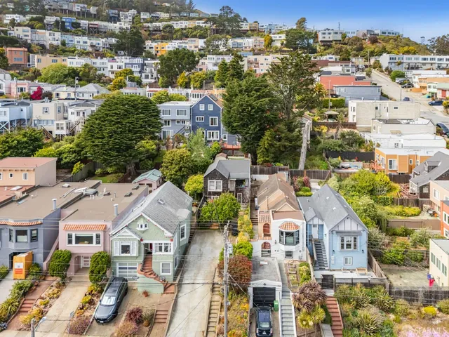an aerial view of residential houses with city view