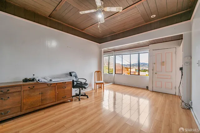 a view of a workspace with furniture and wooden floor