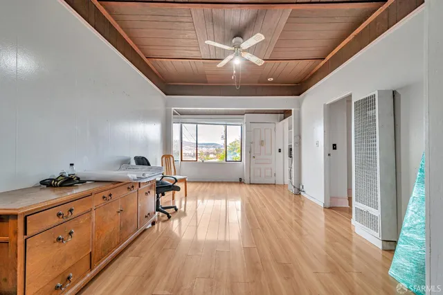 a view of a room with wooden floor and furniture