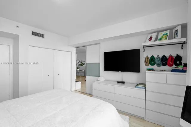 a bedroom with a bed and a flat screen tv