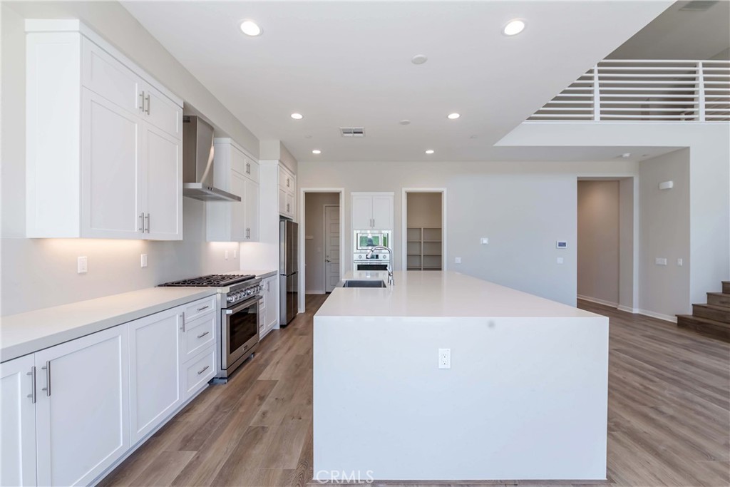 6521 Canyon Oaks Drive Simi Valley, CA 93063 - Photo 10 of 39 a large kitchen with stainless steel appliances granite countertop a lot of counter space and wooden floor