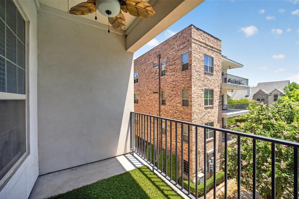 5015 Meridian Lane, Unit 2102 Addison, TX 75001 - Photo 29 of 36 Private balcony featuring a ceiling fan with leaf-shaped blades, concrete flooring partially covered with artificial turf, and black metal railings