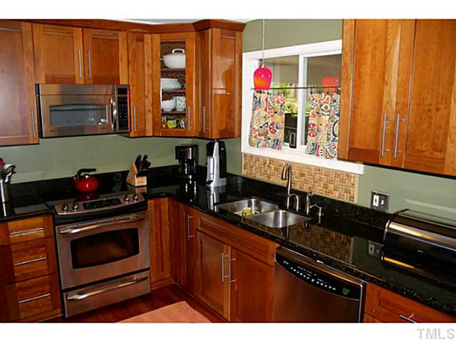 5009 Raintree Court Raleigh, NC 27609 - Photo 3 of 23 a kitchen with stainless steel appliances granite countertop a stove and a microwave