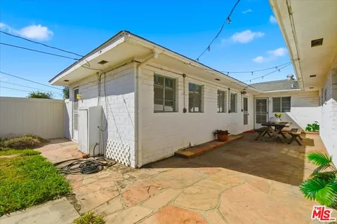 a view of a patio with couple of chairs and potted plants