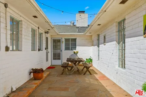 a view of a house with backyard and sitting area