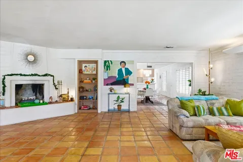 a living room with furniture a large window and bookshelf