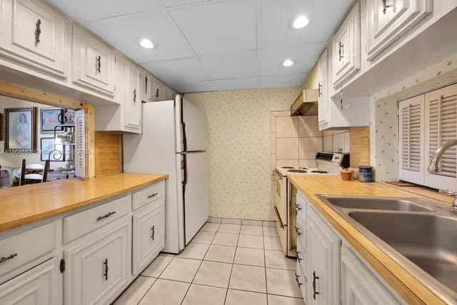 a kitchen with white cabinets and appliances