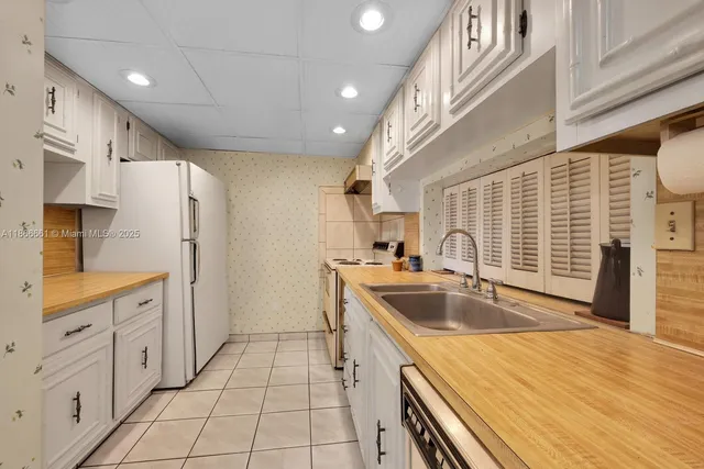 a kitchen with granite countertop a sink stove and cabinets
