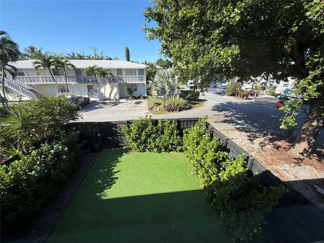 a view of a house with a yard and potted plants