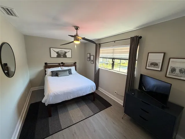 a bedroom with a bed and a tv on the dresser