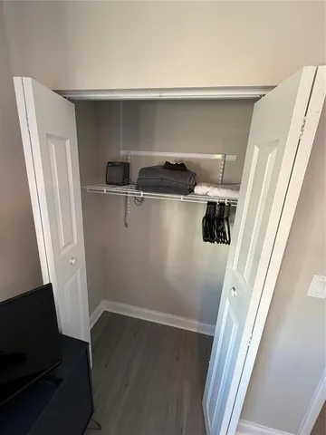 a view of walk in closet with clothes and shoes