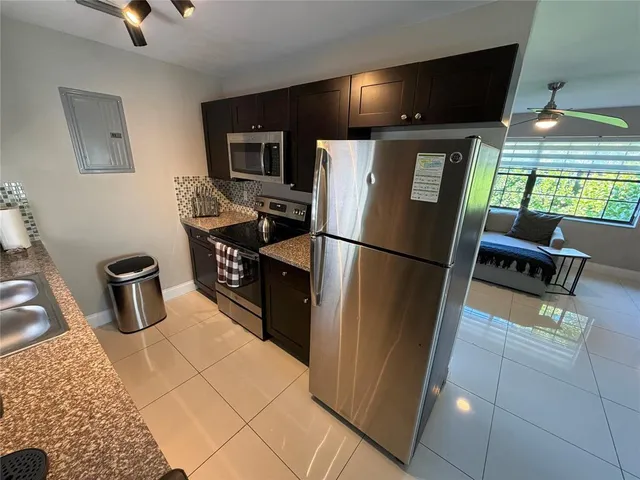 a kitchen with stainless steel appliances granite countertop a refrigerator and a sink