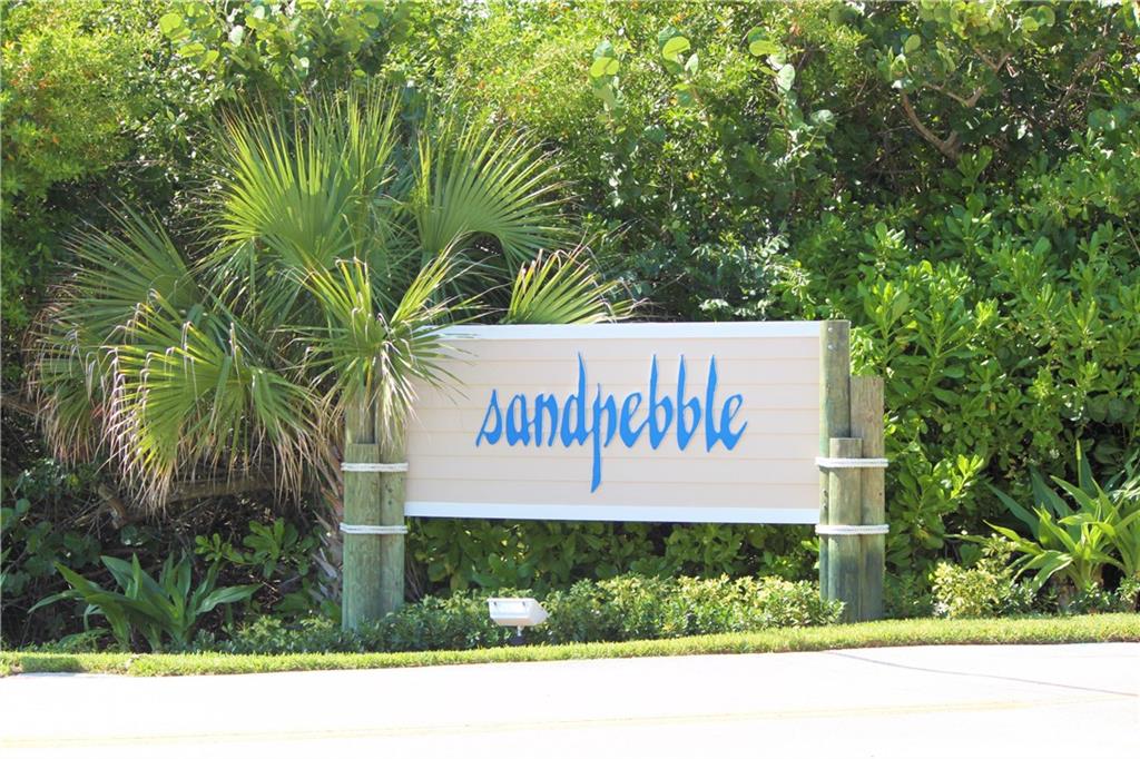 4540 Northeast Sandpebble Trace, Unit 203 Jensen Beach, FL 34957 - Photo 2 of 10 a sign that is on the side of a road