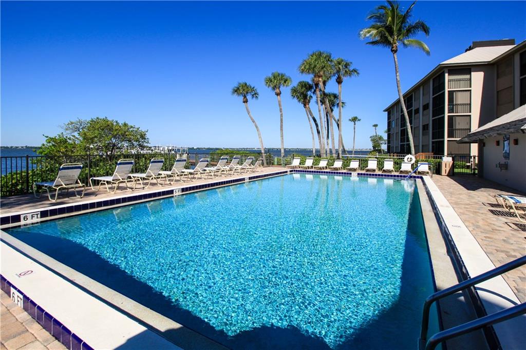 4540 Northeast Sandpebble Trace, Unit 203 Jensen Beach, FL 34957 - Photo 5 of 10 a view of a swimming pool with a table and chairs