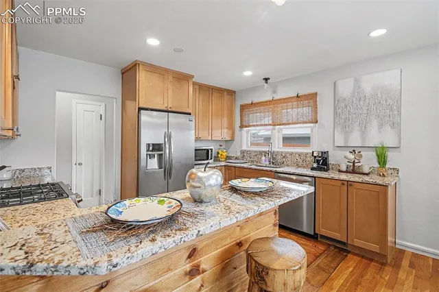 a kitchen with stainless steel appliances granite countertop a sink stove and refrigerator