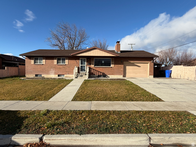 560 South 100 West Tremonton, UT 84337 - Photo 1 of 1 Ranch-style house with brick siding, a chimney, driveway, and an attached garage
