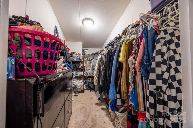 a view of walk in closet with clothes