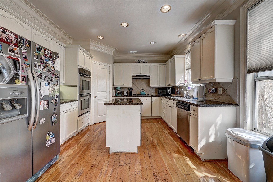 835 Rosine Street Houston, TX 77019 - Photo 11 of 18 a kitchen with stainless steel appliances a refrigerator a sink dishwasher a stove top oven a refrigerator and white cabinets with wooden floor