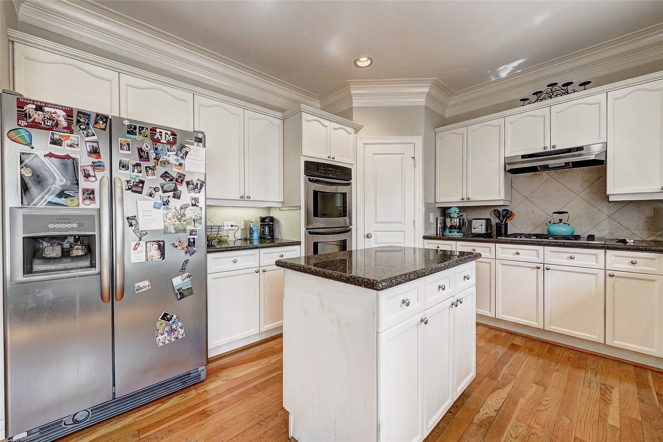 835 Rosine Street Houston, TX 77019 - Photo 12 of 18 a kitchen with white cabinets and stainless steel appliances
