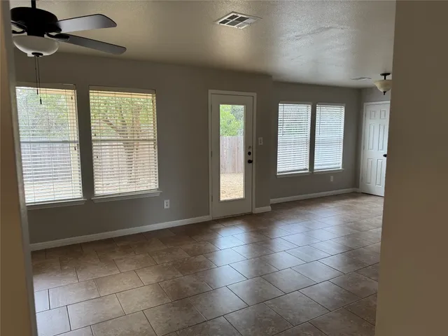 a backyard with wooden fence and a large tree