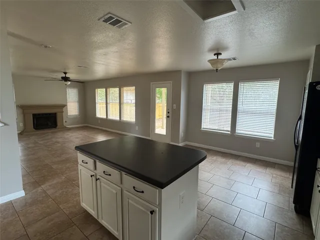 an empty room with windows and fireplace