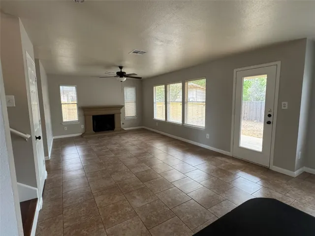 a view of empty room with a fireplace and a window