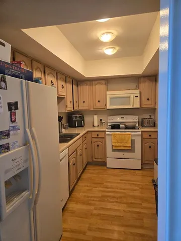 a kitchen with granite countertop a refrigerator stove and sink