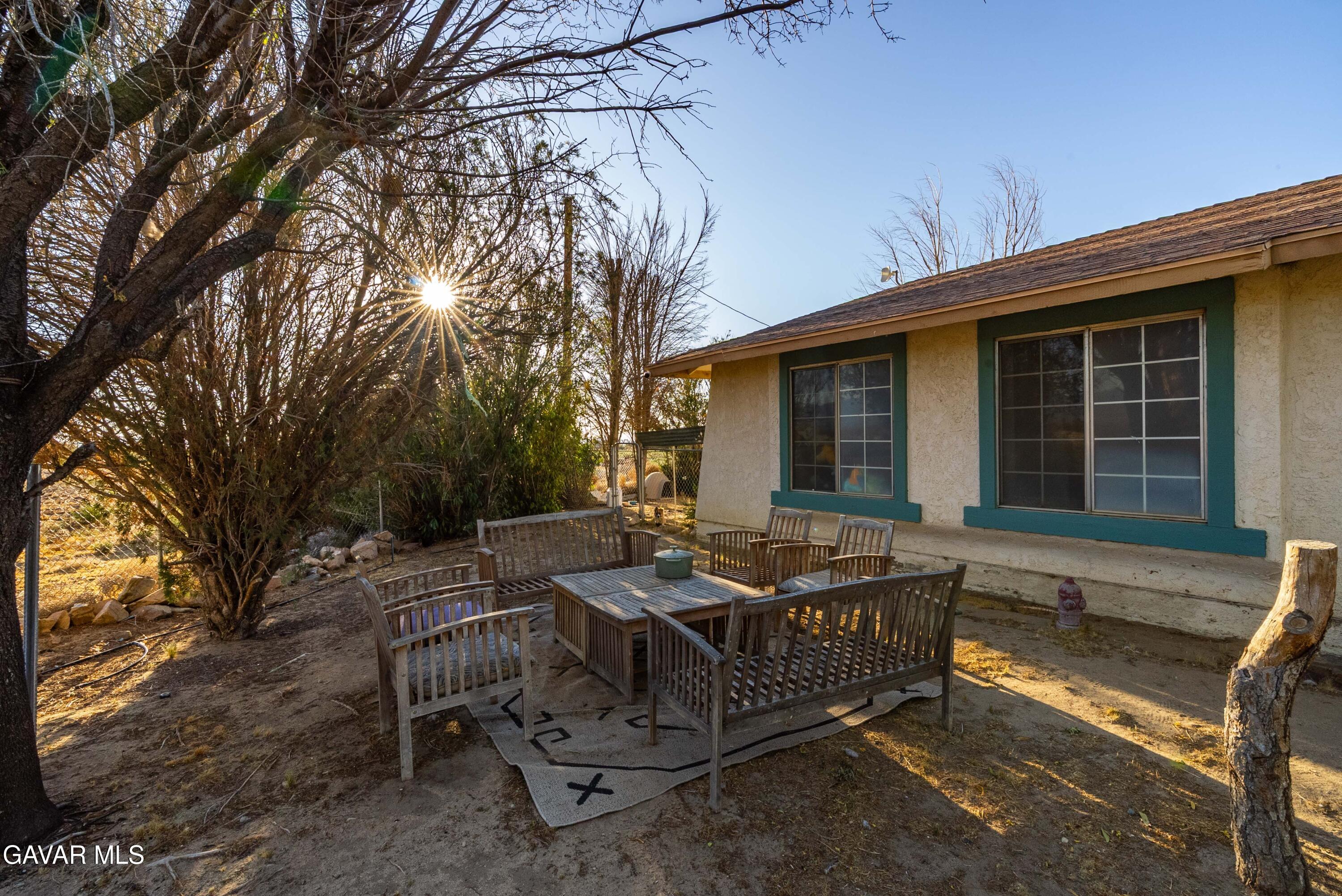 20539 East Ave R Palmdale, CA 93591 - Photo 11 of 55 a view of a wooden chairs and table in backyard of the house