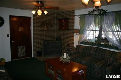 1046 Miller Road Nazareth, PA 18064 - Photo 8 of 33 a living room with furniture a chandelier and a fireplace