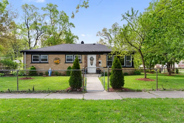 a front view of a house with a yard and trees