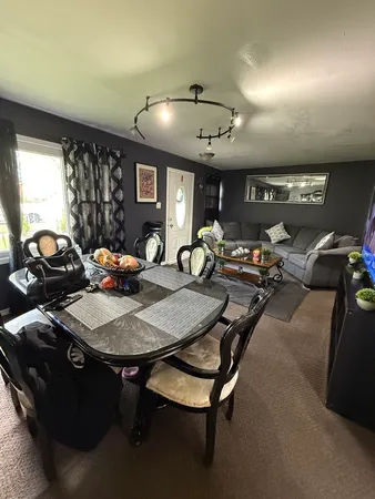 a living room with furniture a air conditioner and a window