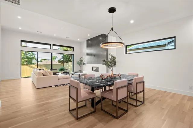 a dining room with furniture a chandelier and wooden floor