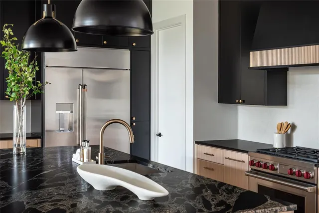 a kitchen with stainless steel appliances granite countertop a stove a sink and a microwave