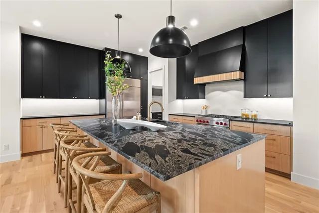 a kitchen with stainless steel appliances granite countertop a sink and a stove