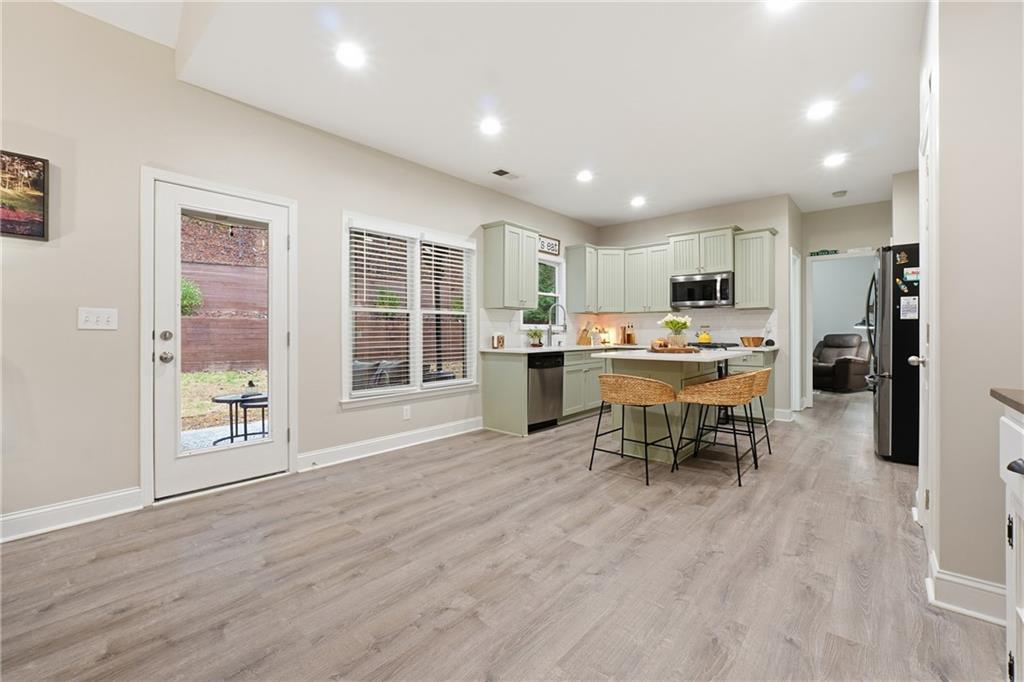 158 Pine Trail Dallas, GA 30157 - Photo 20 of 64 a open kitchen with stainless steel appliances granite countertop a stove top oven a sink dishwasher a dining table and chairs with wooden floor