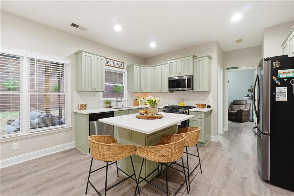 158 Pine Trail Dallas, GA 30157 - Photo 22 of 64 a kitchen with a stove a refrigerator and a dining table
