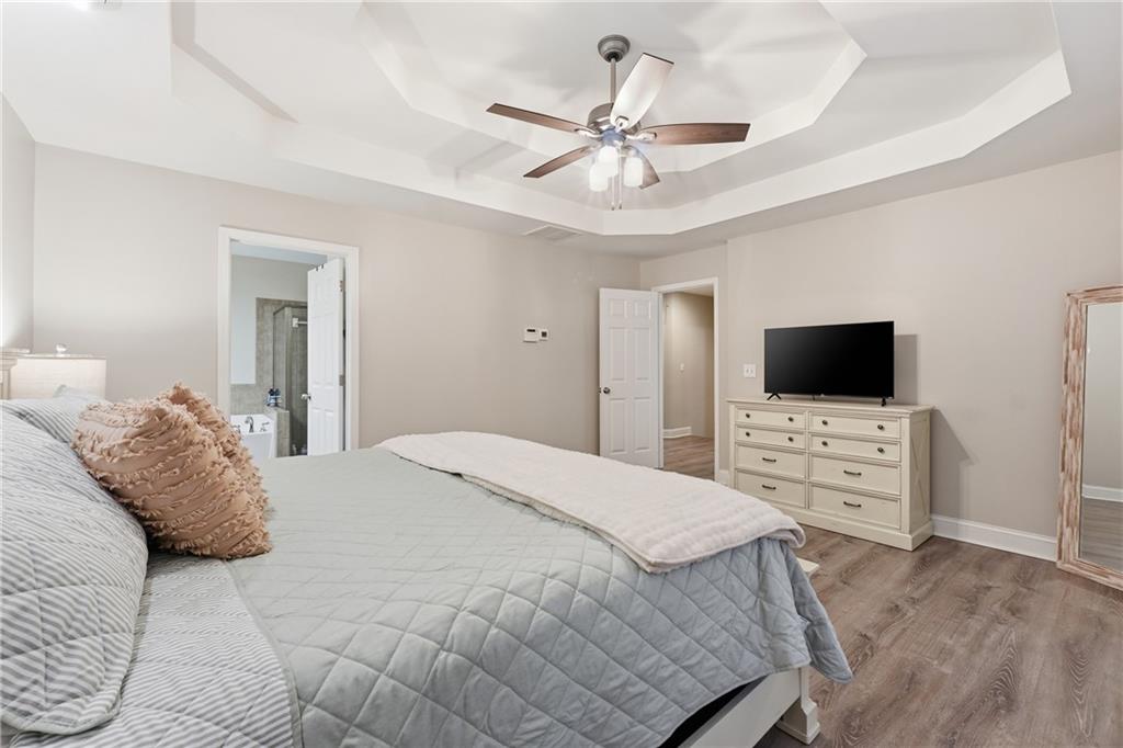 158 Pine Trail Dallas, GA 30157 - Photo 35 of 64 a bedroom with a bed a flat screen tv on dresser and a chandelier