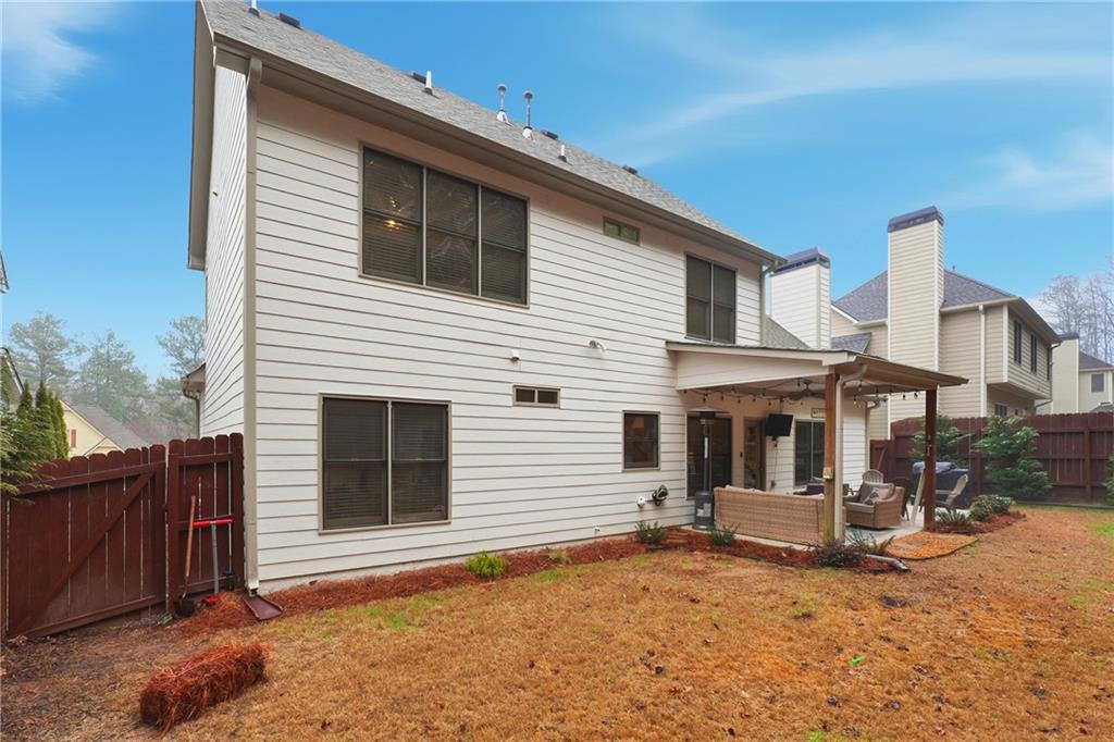 158 Pine Trail Dallas, GA 30157 - Photo 55 of 64 a view of a white house with large windows and wooden fence