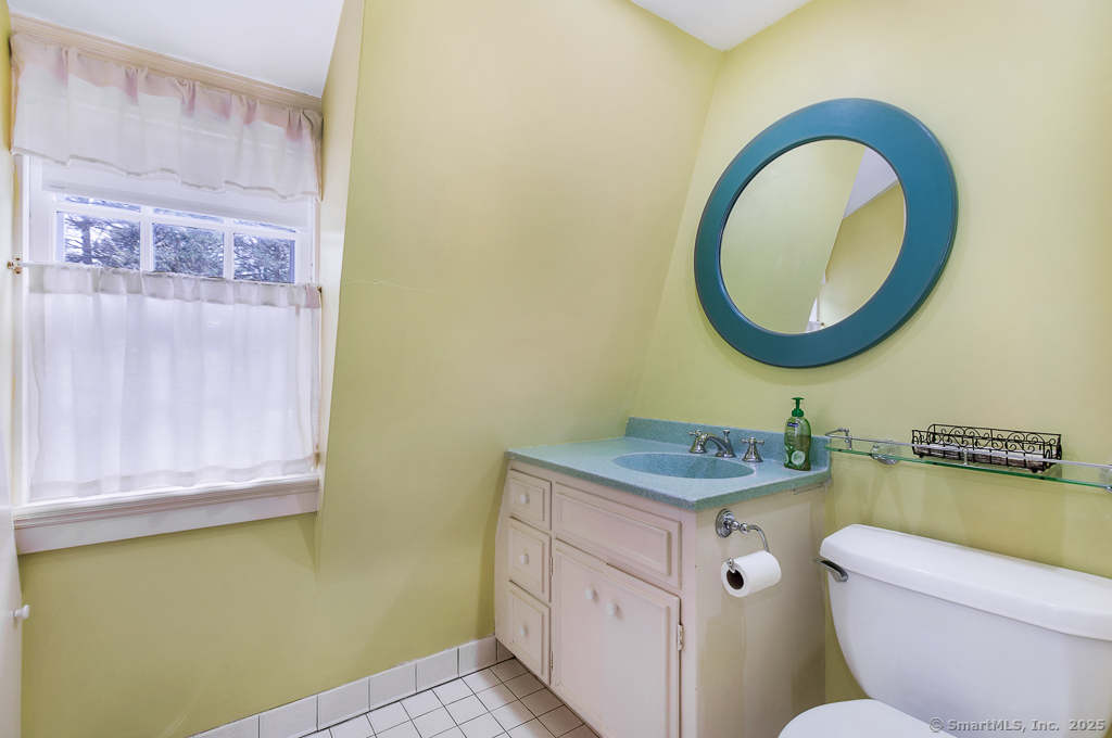 71 Beecher Road Woodbridge, CT 06525 - Photo 11 of 32 a bathroom with a toilet a sink and a mirror