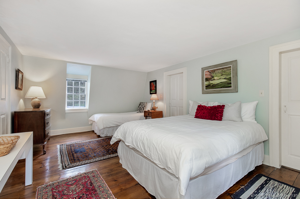 71 Beecher Road Woodbridge, CT 06525 - Photo 19 of 32 a bedroom with a bed and wooden floor