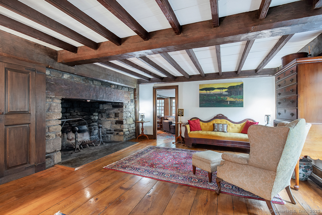 71 Beecher Road Woodbridge, CT 06525 - Photo 5 of 32 Historic living room with antique Colonial charm. Massive fieldstone fireplace with rustic wood beam mantel, evoking early New England craftsmanship.