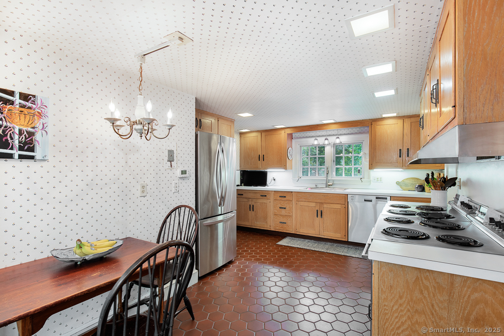 71 Beecher Road Woodbridge, CT 06525 - Photo 9 of 32 a kitchen with a table chairs stove and cabinets